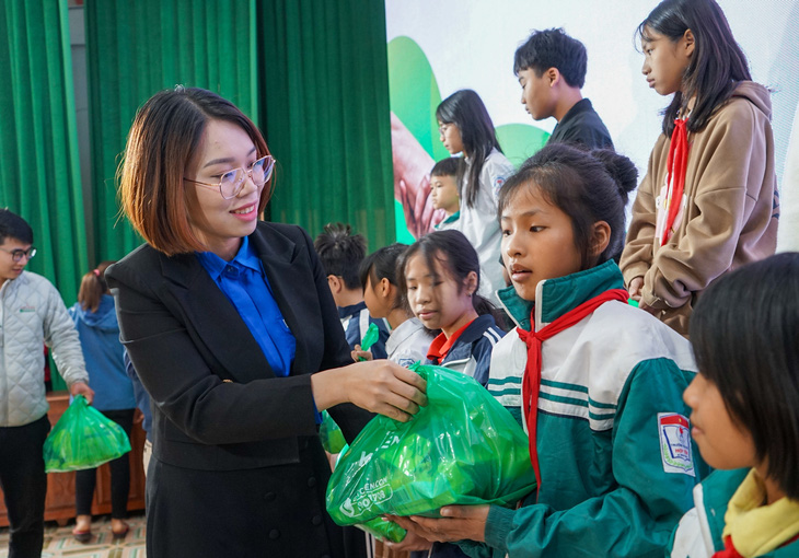  Chị Dương Thị Hương Giang - phó bí thư Tỉnh Đoàn Hải Dương - trao quà của nhà tài trợ cho các em học sinh khó khăn - Ảnh: VŨ TUẤN