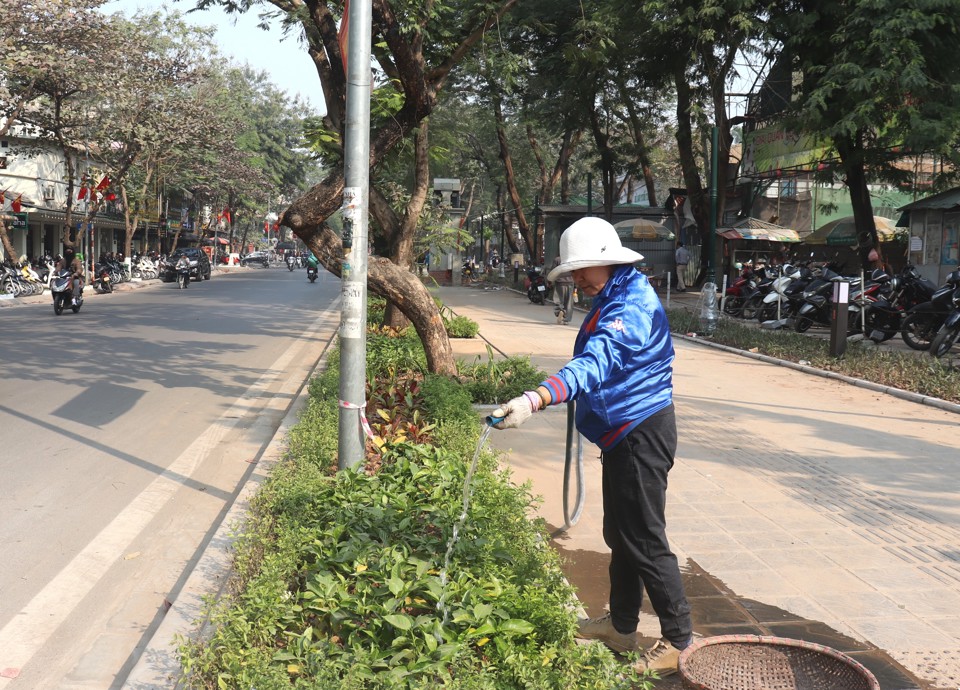  Công nhân thực hiện chăm sóc dải bồn cây xanh được bố trí dọc toàn tuyến tạo hàng rào ''mềm'' ngăn cách ranh giới Công viên Tuổi trẻ Thủ đô với hè phố, đường giao thông