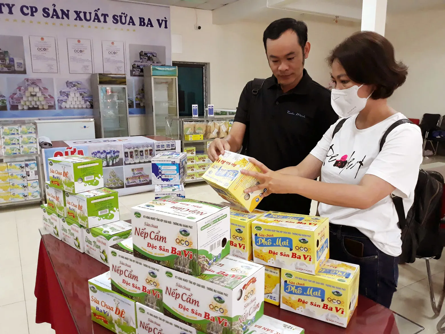 Người tiêu dùng mua sản phẩm sữa Ba Vì tại điểm bán và giới thiệu sản phẩm OCOP huyện Ba vì. Ảnh: Hoài Nam