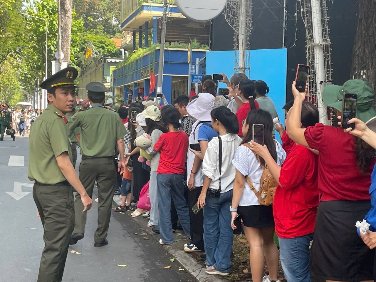 Người dân xếp hàng tìm vị trí đẹp xem diễu binh kỷ niệm 50 năm ngày thống nhất đất nước - Ảnh: Thủy Long