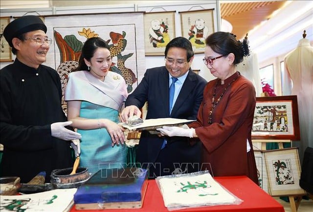 Thủ tướng Phạm Minh Chính và Thủ tướng Paetongtarn Shinawatra cùng trải nghiệm làm tranh dân gian Đông Hồ. Ảnh: TTXVN