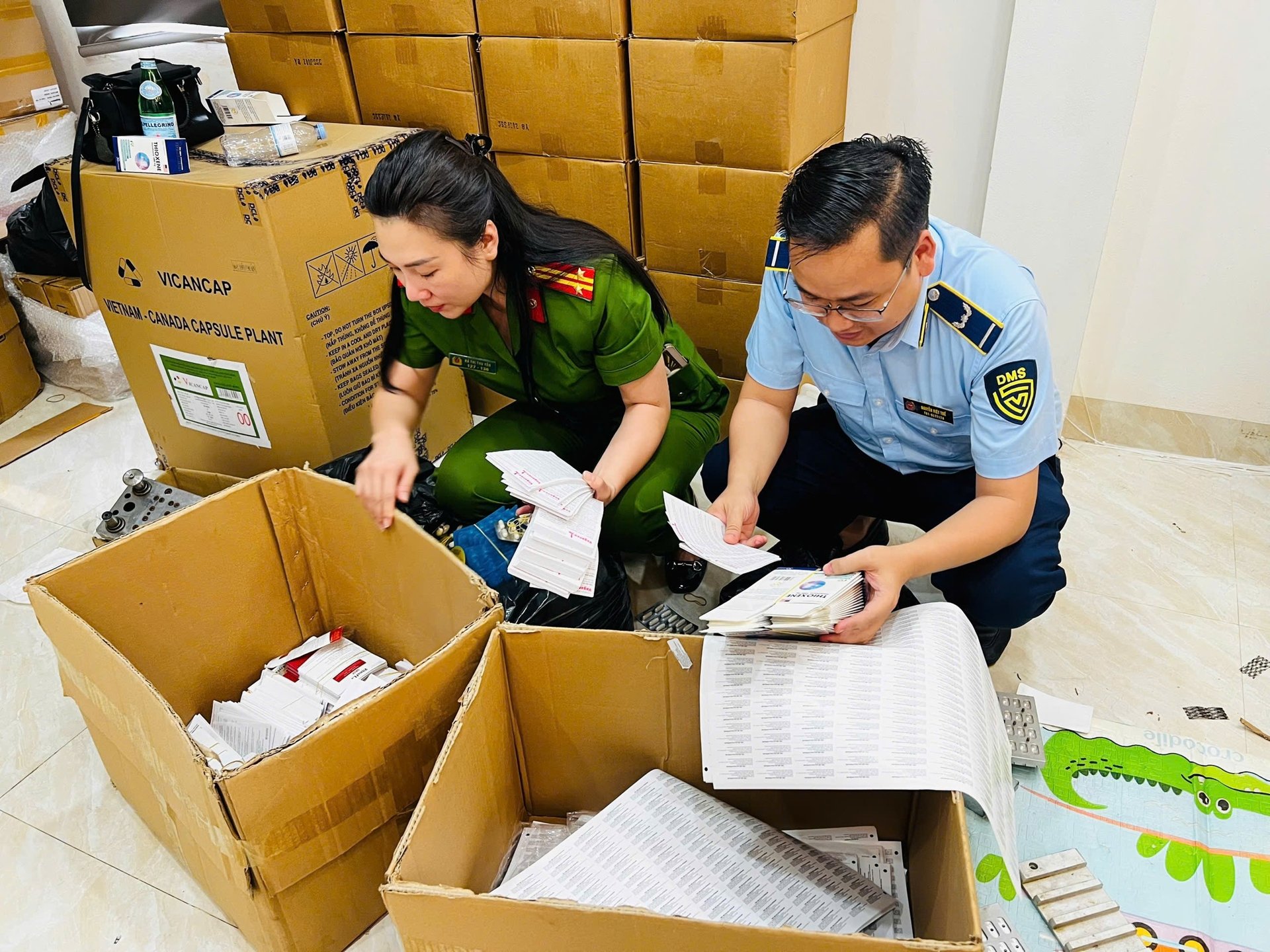 Lực lượng chức năng khám xét các địa điểm liên quan đến ổ nhóm sản xuất thực phẩm chức năng giả tại Hà Nội. Ảnh: Ngọc Bích