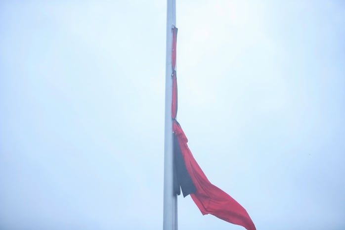 Lá cờ rủ với dải băng tang đã được treo lên cột