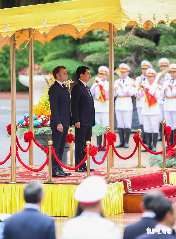 Hai nhà lãnh đạo đứng nghiêm khi quốc thiều hai nước được cử lên - Ảnh: NGUYỄN KHÁNH