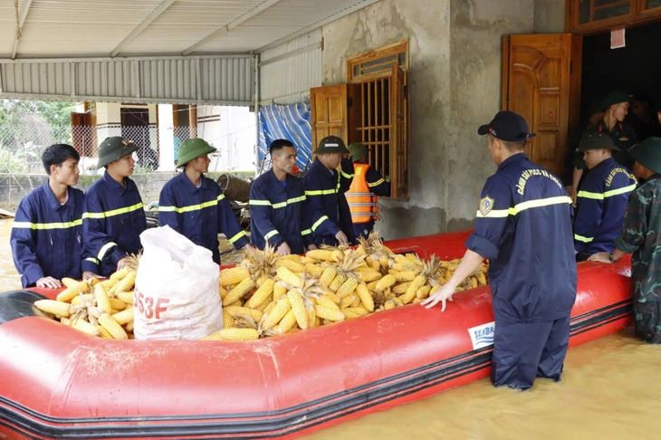 Lực lượng công an hỗ trợ người dân di chuyển tài sản ra khỏi khu vực ngập sâu - Ảnh: ĐINH AN