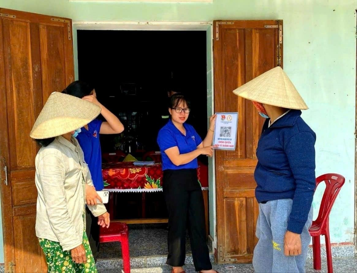 Cán bộ Đoàn Thanh niên xã Duy Xuyên hướng dẫn người dân tham gia vào nhóm zalo phòng chống tội phạm. Ảnh: P.T.