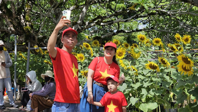 Một gia đình mặc áo cờ đỏ sao vàng tham quan Đại nội Huế.
