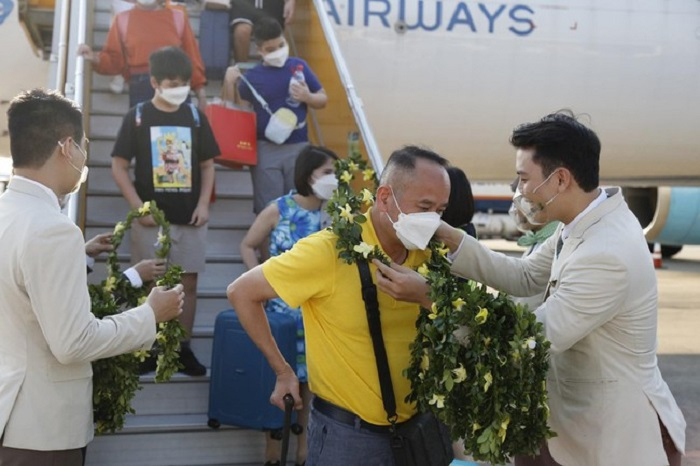 Hành khách tham gia chuyến bay nhận hoa chào mừng từ đại diện Bamboo Airways. - Ảnh: nhipsongkinhdoanh