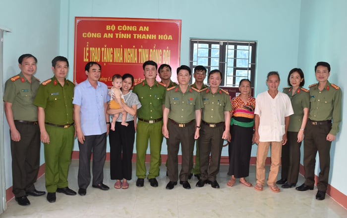 Đoàn công tác Công an tỉnh Thanh Hóa chụp ảnh lưu niệm với gia đình Trung úy Vi Văn Dưỡng trong căn nhà mới vừa được xây dựng