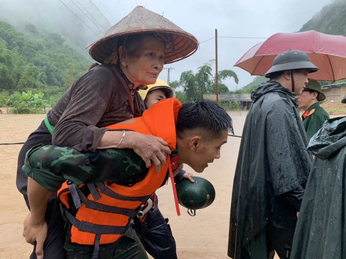 Cán bộ, chiến sĩ Bộ Chỉ huy Quân sự tỉnh phối hợp với lực lượng Công an tỉnh Sơn La giúp nhân dân vượt suối an toàn. Ảnh: VOV