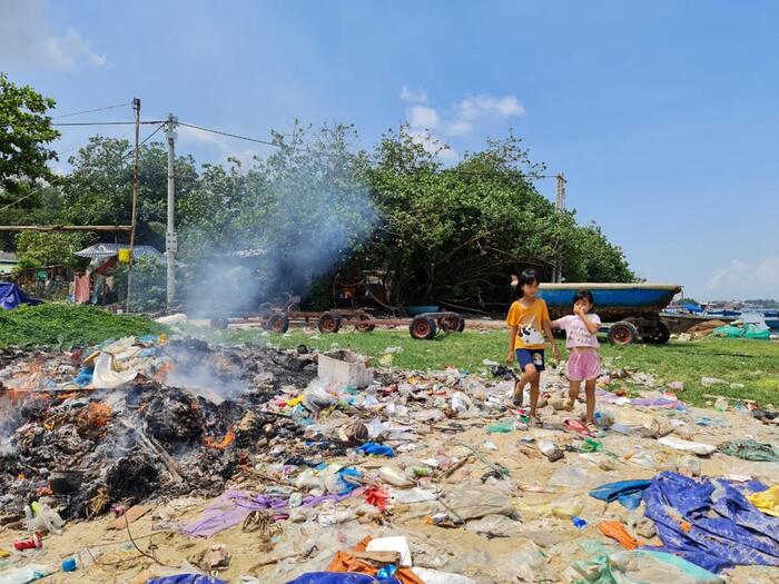 Trẻ em vui chơi trên khu vực bờ biển ngập rác ở thôn Sơn Trà.