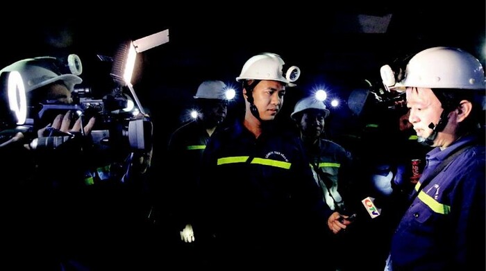 Phóng viên tác nghiệp trong hầm lò tại Công ty CP Than Vàng Danh (Quảng Ninh). (Ảnh: Báo Quảng Ninh)