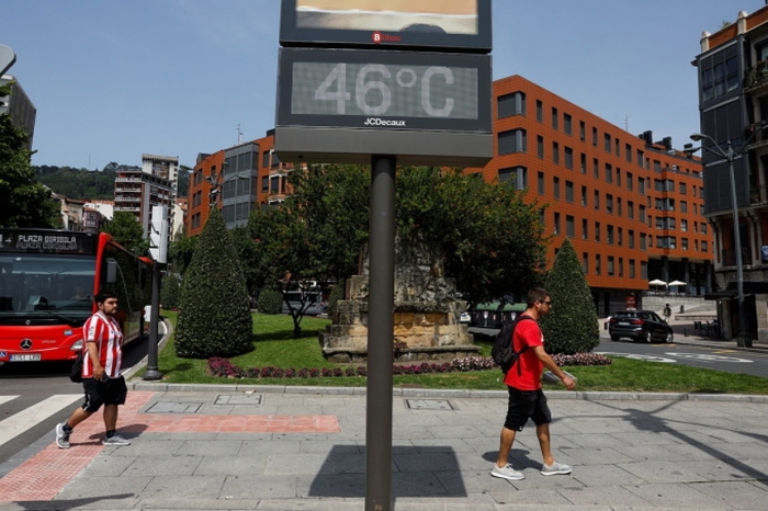 Người dân đi qua một biển báo nhiệt độ 46 độ C tại Bilbao, Tây Ban Nha ngày 17/6. Ảnh: Reuters.
