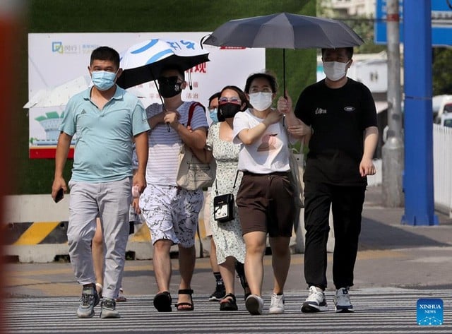 Người dân đeo khẩu trang khi đi lại trên một tuyến phố ở quận Mẫn Hàng, phía Đông thành phố Thượng Hải của Trung Quốc, ngày 10/7/2022.