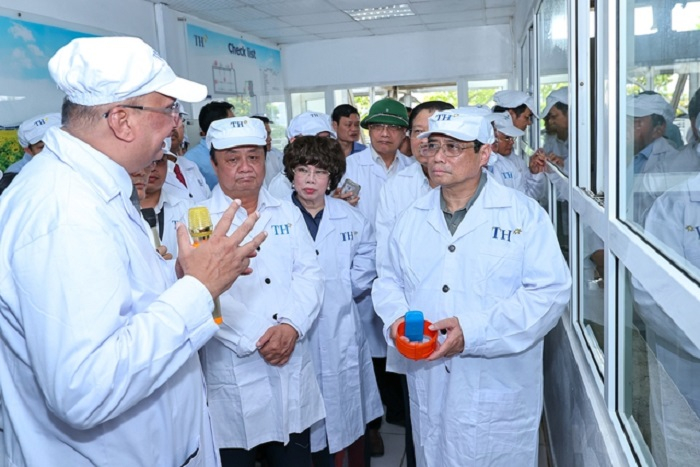 Thủ tướng Phạm Minh Chính nghe giới thiệu về công nghệ chăn nuôi bò sữa tập trung của Tập đoàn TH - Ảnh: VGP/Nhật Bắc
