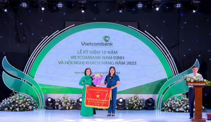 Thay mặt UBND tỉnh Nam Định, bà Hà Lan Anh - Phó Chủ tịch UBND tỉnh tặng Cờ “Đơn vị dẫn đầu phong trào thi đua” cho Vietcombank Nam Định.