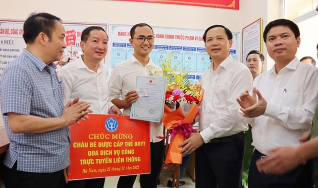Phó Tổng Giám đốc BHXH Việt Nam Chu Mạnh Sinh trao thẻ BHYT đầu tiên trên toàn quốc cho bé gái dưới 6 tuổi được thực hiện qua dịch vụ công liên thông