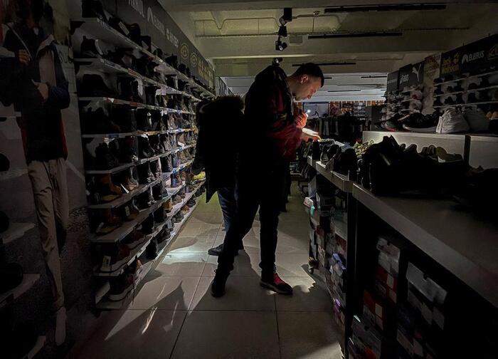 Một người dần ông mua sắm ở trung tâm thương mại bị mất điện tại thủ đô Kiev, hôm 26/11. Ảnh: Reuters