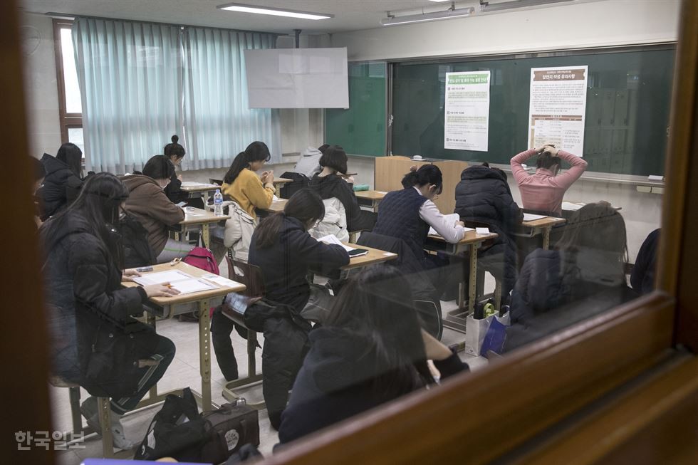   Thí sinh ngồi chờ đến giờ thi tại trường trung học Pohang Idong ở Nam-gu, Pohang, tỉnh Gyeongsang Bắc, Hàn Quốc.  