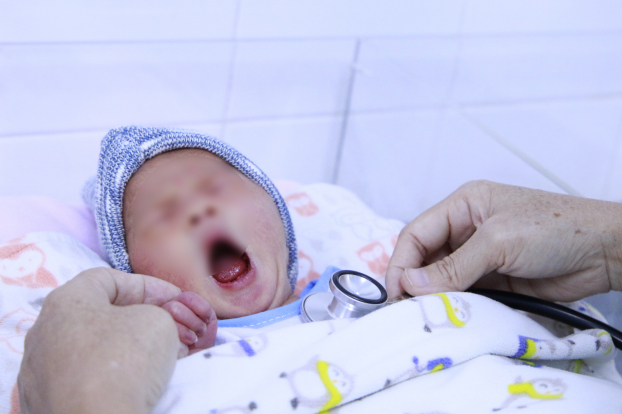   Em bé chào đời khỏe mạnh và đang được nhân viên y tế kiểm tra sức khỏe  