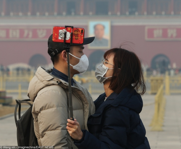   Cặp đôi Trung Quốc đeo khẩu trang chụp ảnh selfie ở Thiên An Môn trong không khí đầy khói bụi ô nhiễm ở Bắc Kinh  