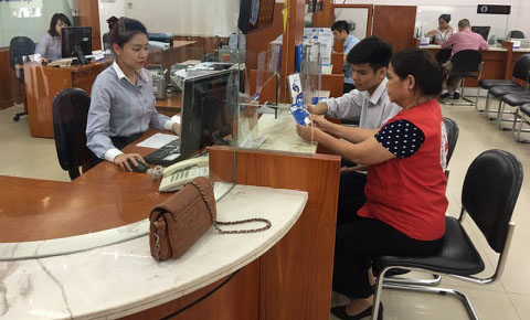   Cháu Trần Đức Anh và bà Trần Thị Thanh Yến, Chủ tịch Hội Chữ Thập đỏ phường Phương Liên (quận Đống Đa) tới ngân hàng để làm sổ tiết kiệm.  