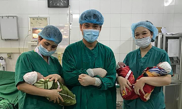   Ba bé trai được nhân viên y tế chăm sóc sau sinh  