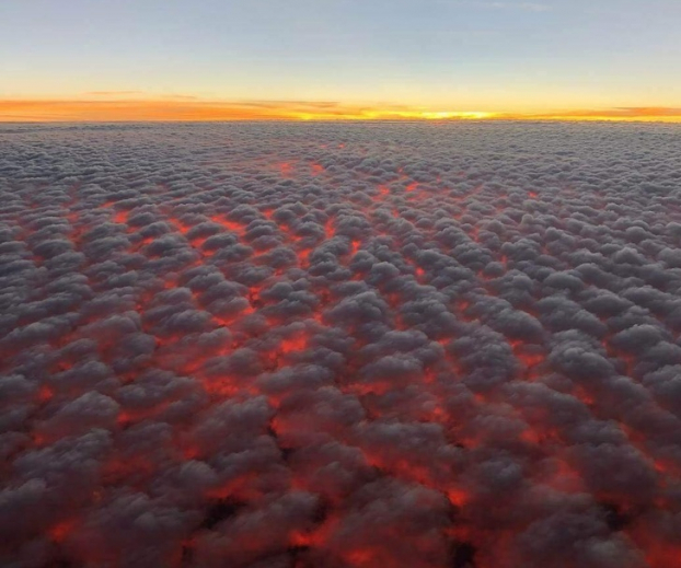   Mặt trời lặn trên những đám mây trông giống như dung nham giữa bầu trời  