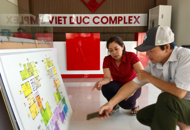   Bà Lan Anh (áo đỏ) đang tư vấn cho khách hàng có nhu cầu mua căn hộ tại dự án Chung cư Việt Đức Complex (ở phố Nguyễn Tuân, Cầu Giấy)  