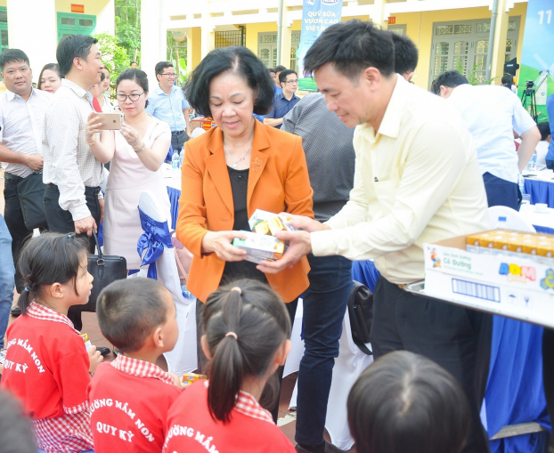   Bà Trương Thị Mai - Ủy viên Bộ Chính trị, Bí thư Trung ương Đảng, Trưởng ban Dân vận Trung ương trao những hộp sữa của Quỹ sữa vươn cao Việt Nam đến các em học sinh tham dự chương trình  