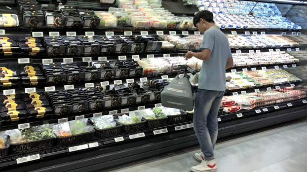   Nhân viên của siêu thị Hema đang lấy các hàng hóa do khách hàng đặt, cho vào giỏ hàng và chuyển đến khâu tiếp theo bằng hệ thống băng chuyền lắp đặt trên trần  