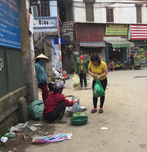   Một phụ nữ đi chợ cóc mua thực phẩm không đeo khẩu trang phòng bệnh  