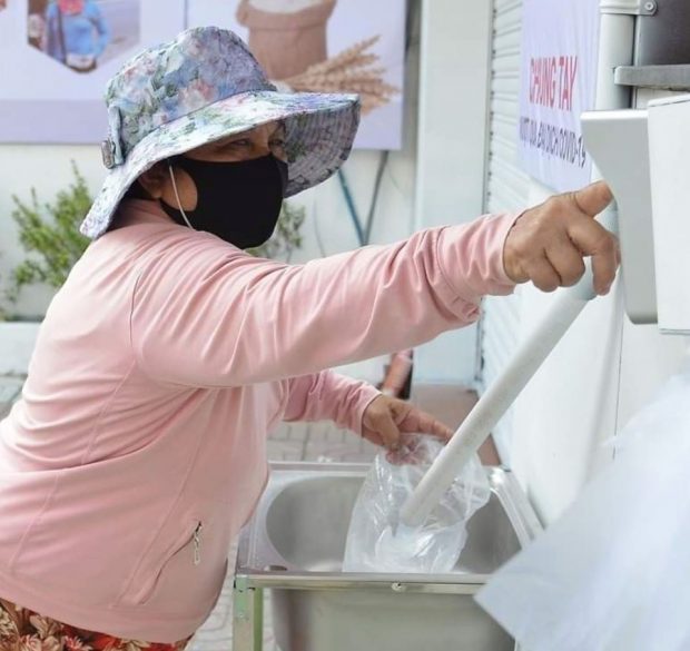   Một người dân đang lấy gạo ở cây 'ATM'  
