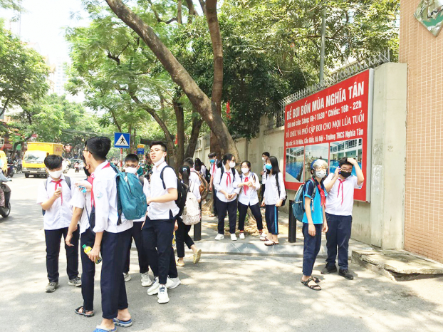   Học sinh trường THCS NGhĩa Tân (Cầu Giấy) khi tan học vẫn túm năm tụm ba ngoài cổng trường, thậm chí không đeo khẩu trang.  