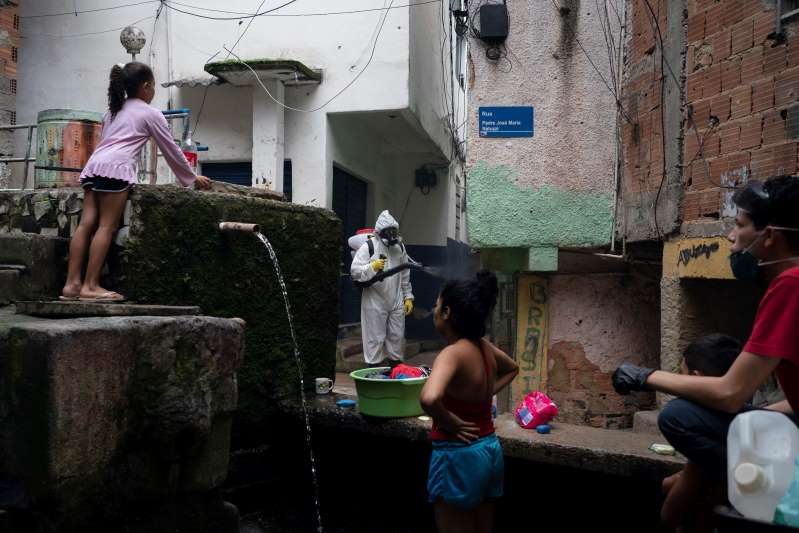  Trẻ em nghèo ngơ ngác nhìn nhân viên xịt khử trùng tại Rio de Janeiro, Brazil  