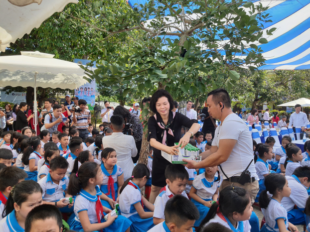   Các em học sinh trường Kim Đồng hồ hởi đón nhận những hộp sữa đầu tiên trong chương trình sữa học đường từ bà Bùi Thị Hương – Giám đốc Điều hành Vinamilk .  
