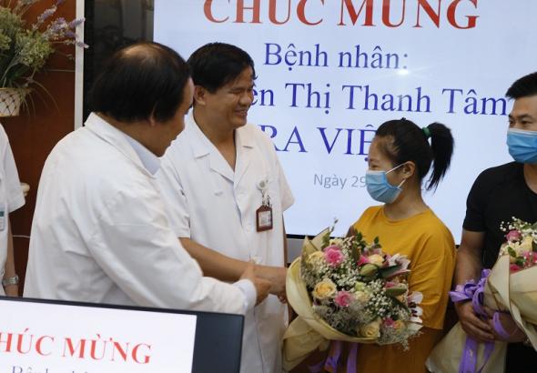   PGS.TS Đào Xuân Cơ và PGS.TS Nguyễn Văn Chi tặng hoa chúc mừng bệnh nhân ra viện  