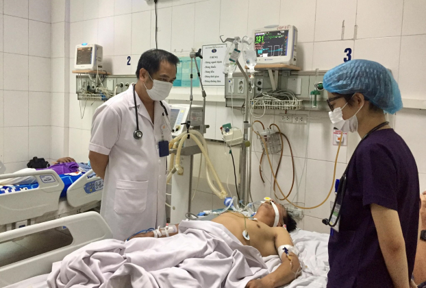   Bác sĩ Nguyễn Trung Cấp (bên phải) đang thăm khám cho bệnh nhân nặng điều trị tại BV Bệnh Nhiệt đới Trung ương  