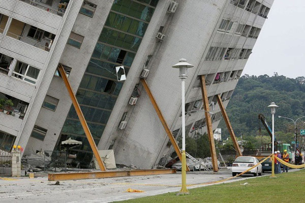   Một tòa nhà bị nghiêng sau động đất và được chống đỡ bởi những cột chống.  