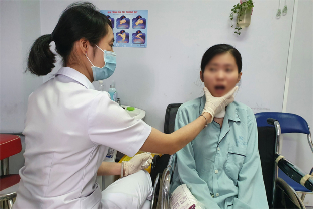   Bệnh nhân tập vật lý trị liệu co giãn cơ miệng trước khi xuất viện  