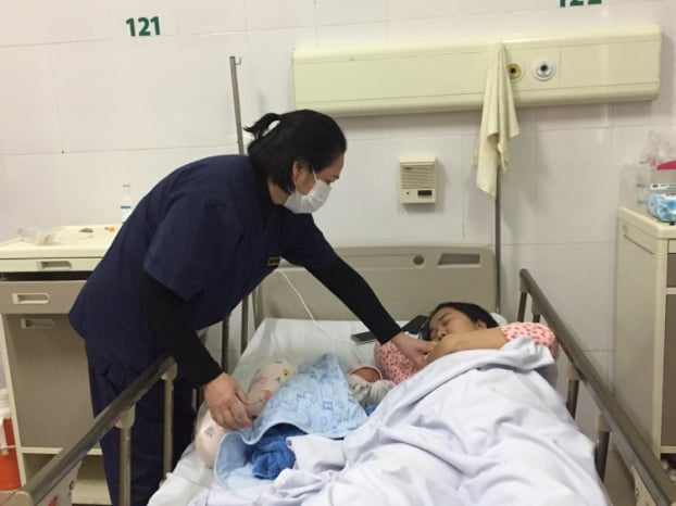   Nữ hộ sinh Hoàng Thị Thu Hằng chăm sóc cho mẹ con sản phụ sau sinh  