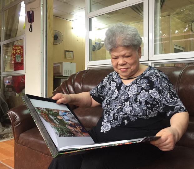  Bà Nguyễn Thị Liệu ngồi xem lại những bức ảnh chụp cùng người bạn già tri kỷ khi đến viện dưỡng lão  