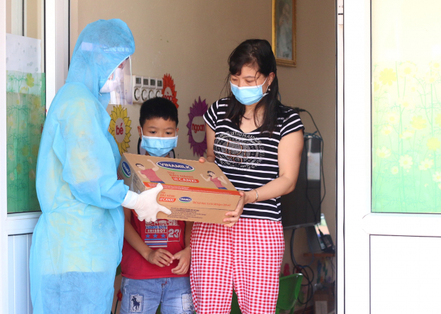   Người dân, trẻ em trong nơi cách ly tập trung tại huyện Thuận Thành, một trong những điểm nóng về dịch ở Bắc Ninh, đón nhận món quà từ Vinamilk  