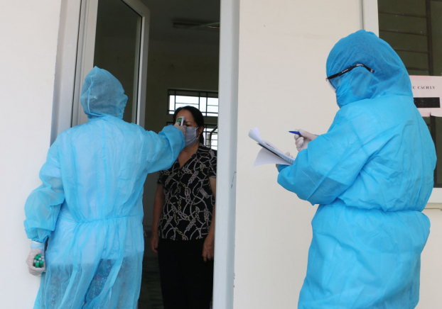   Nhân viên y tế tiến hành kiểm tra thân nhiệt cho người dân đang phải cách ly phòng chống dịch lây lan. Ảnh minh họa  