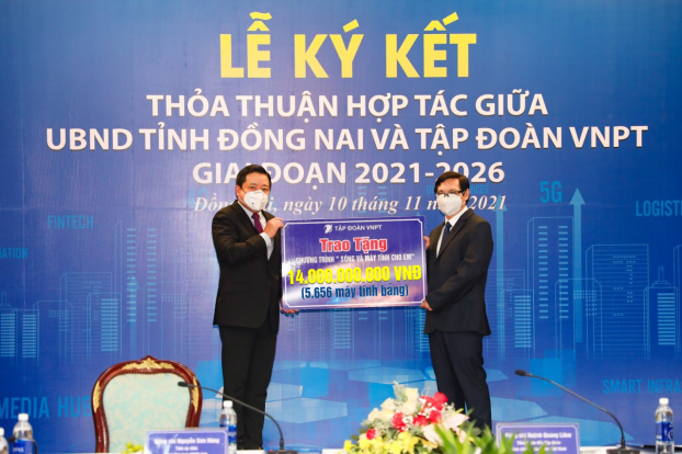   Tổng giám đốc VNPT Huỳnh Quang Liêm (bên trái) và Phó chủ tịch UBND tỉnh Đồng Nai Nguyễn Sơn Hùng (bên phải) thực hiện nghi lễ trao nhận 5.656 máy tính bảng  