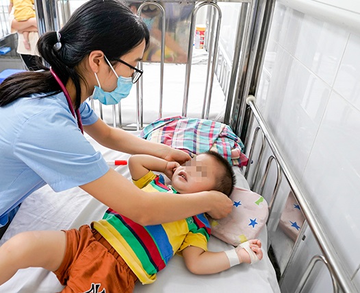   Nhân viên y tế BV Nhi Trung ương đang chăm sóc cho bệnh nhi bị tay chân miệng phải nhập viện điều trị  