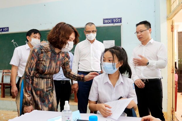 Thứ trưởng Nguyễn Thị Liên Hương động viên các em học sinh tại buổi tiêm chủng.