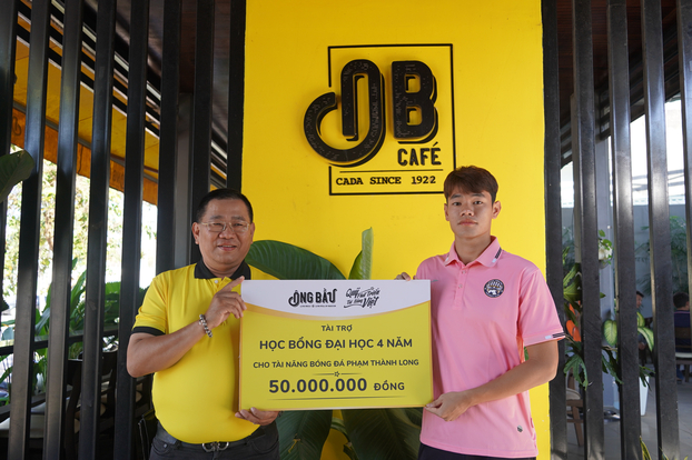 Tài năng bóng đá Phạm Thành Long nhận bảng tượng trưng học bổng từ đại diện Quỹ Phát triển Tài năng Việt của Ông Bầu