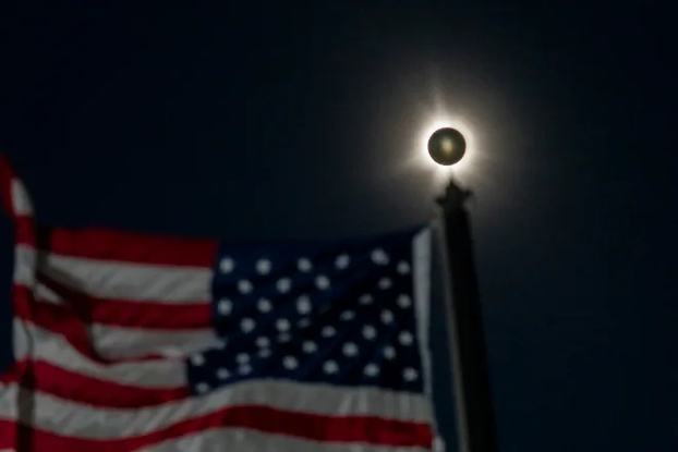 Nhật thực toàn phần bên cạnh hình ảnh lá cờ Mỹ tại Houlton, Maine (Mỹ). Ảnh: Jasper Colt/USA TODAY