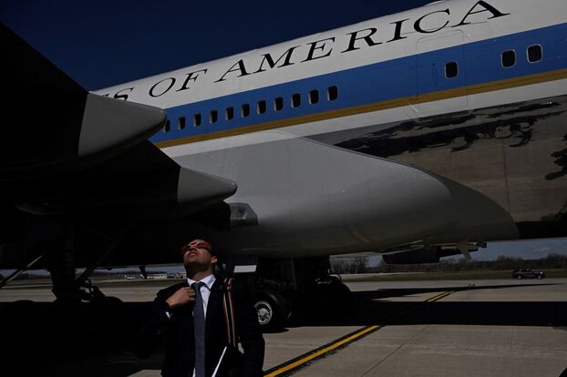 Một nhân viên Nhà Trắng đang xem nhật thực khi Tổng thống Mỹ Joe Biden đến sân bay khu vực hạt Dane ở Madison (Mỹ). Ảnh: Andrew Caballero-Reynolds/AFP/Getty Images